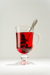Transparent glass Cup with hot red tea from hibiscus or hibiscus.