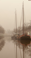 Old boats in fog in canal. Meppel drente Netherlands