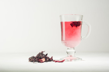Transparent glass Cup with hot red tea from hibiscus or hibiscus.