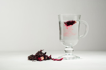 Transparent glass Cup with hot red tea from hibiscus or hibiscus.