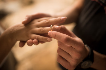 hands of couple in love with a ring of marriage proposal on the tropical beach in Bali - obrazy, fototapety, plakaty
