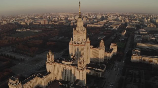 Aerial footage of stalins ussr skysraper in Moscow center. Spring. Sunset. Sun glare. HEVC/H.265, D-Cinelike, Dlog-M,