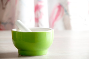 Ceramic mortar and pestle on wooden table