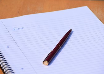 notebook and pen on wooden background