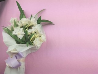 Bouquet of white flowers on pink background.