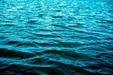 Texture and background of small waves of a calm sea. Quiet coastal aquamarine waves