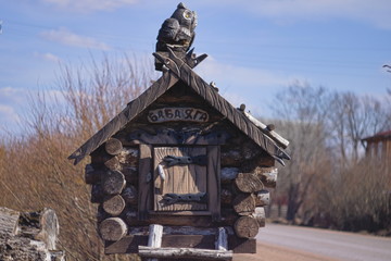 Fototapeta premium The wooden hut of the witch in the fairy tale with the figure of an OWL on the roof