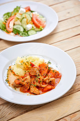 chicken with mashed potatoes and salad on the wooden background