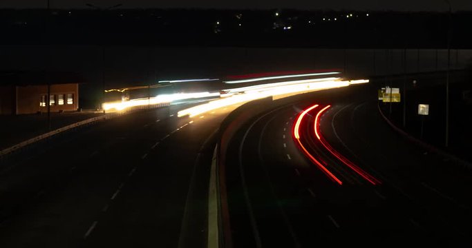 Busy street road traffic lights in time lapse at night. Hyper speed urban movement view from the bridge