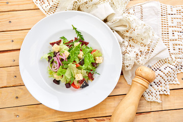 vegetarian salad with dried tomatoes and croutons on the wooden background