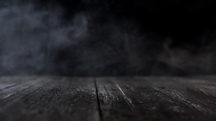 wooden table with dark smoky background . copy space