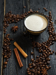 Cappuccino coffee mug with coffee beans on wooden table