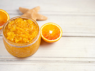 Orange scrub with sea salt on wooden white table copy space