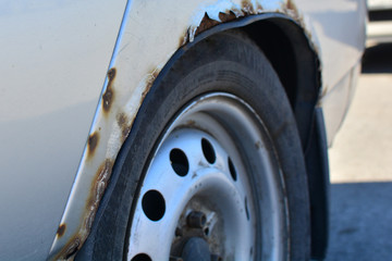Fototapeta premium Fragment of a car with rust. The car body element is corroded. Concept: corrosion resistance, car body repair, rust protection.