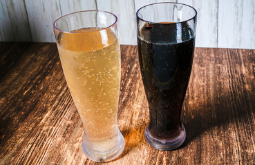 Two beer on a bar next to a wall.