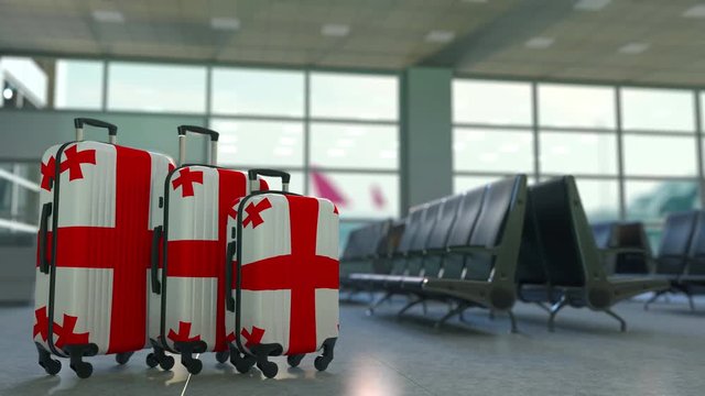 Travel suitcases with flag of Georgia. Georgian tourism conceptual animation