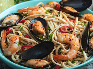 Noodles with shrimp and mussels , spice , on the plate. Closeup. Chinese/Japanese/Asian noodles