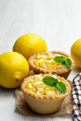 Egg custard tarts with jellied lemon on white wooden table