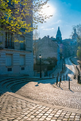 Paris, Montmartre, a very romantic parisian street with a vintage lamppost, sunrise, the Sacre-Coeur basilica in background 