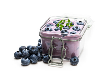 Fresh blueberries yogurt in glass jar isolated on white