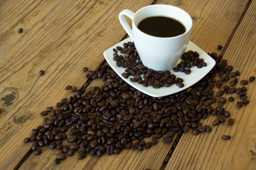 cup of coffee and beans on wooden table