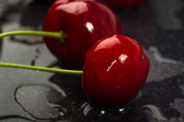 large ripe red sweet cherries in a black dish, close-up