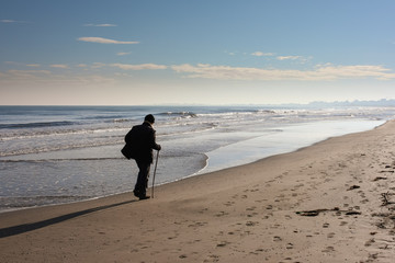 Anziano che passeggia in spiaggia