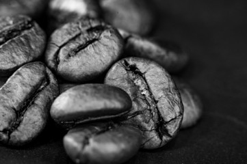 Brown roasted coffee beans on black background, close up, macro