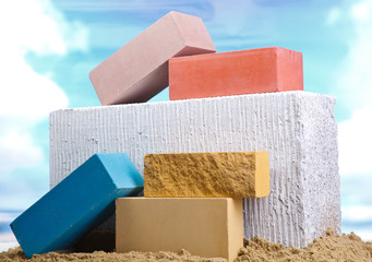 Set of multi-colored ceramic bricks on the sand at the blue sky background