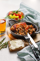 Vegetarian food. Fried mushrooms and egg in cast iron pan. Ingredients for rustic breakfast on wooden table.