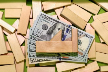 Investments in aviation, airplanes. Airplane, built on dollar bills, in a box with a wooden constructor.