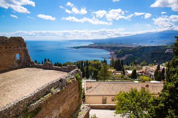 The Greek Theatre in Taormina, Mediterranean sea and Etna volcano panorama, Sicily island, Italy. Bright summer day. 