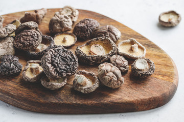 Macro photography of Chinese dried mushrooms Shiitake on a wooden kitchen board.