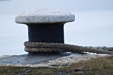 Ship rope tied to a metal pole on the pier