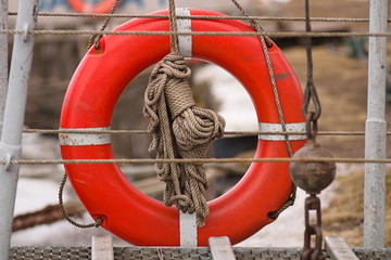 Red lifebuoy at ship deck on blue sky background