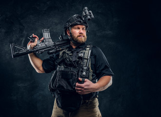 A brave special forces soldier wearing combat uniforms with modern devices posing with an assault...