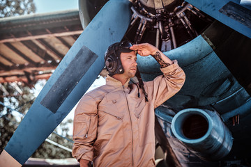Young pilot is standing near his jet. © Fxquadro
