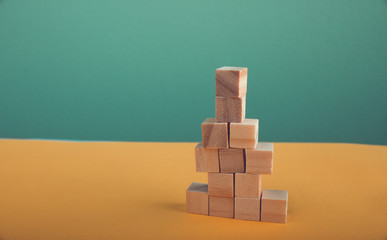 Business concept for growth with process obstacles. stack of wooden block on yellow green background