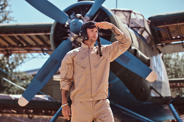 Young pilot is standing near retro jet.