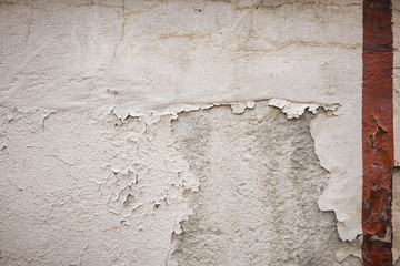 white wall, detail of an abandoned and crumbling wall red stripe.