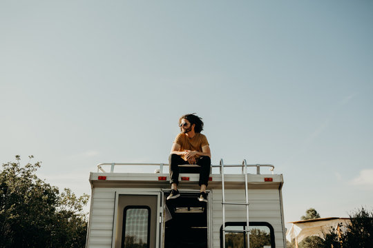 guy sitting on top of a camper trailer