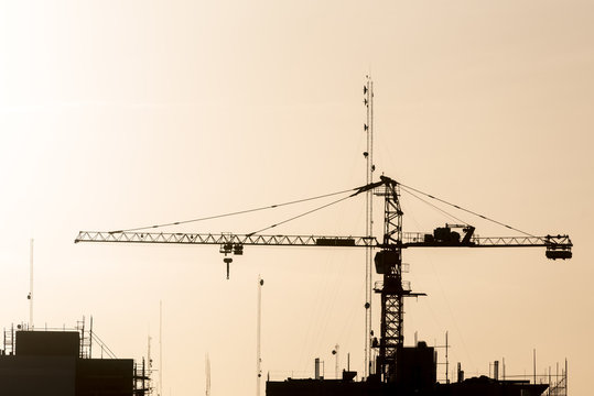 Silhouette of crane on site
