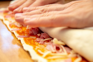 Obraz na płótnie Canvas woman rolls the pizza to little pieces