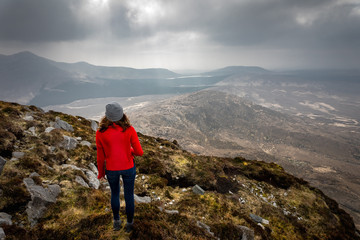 Fototapeta premium une jeune femme en tenue de trekking au sommet d'une montagne 