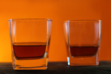 Glasses with a drink on a wooden board. red yellow background.