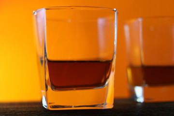 Glasses with a drink on a wooden board. red yellow background.