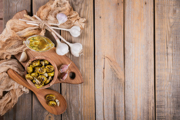 Grilled olives with garlic, olive oil and spices on rustic wooden table