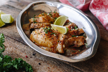 Baked chicken with spices and lime. Homemade. Wooden