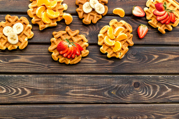 Traditional belgian waffles with fruit topings on wooden background top view mock up