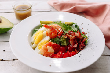 King prawns salad with egg, cherry,  shrimp avocado and vegetables. Sauce. Dinner. Healthy food.